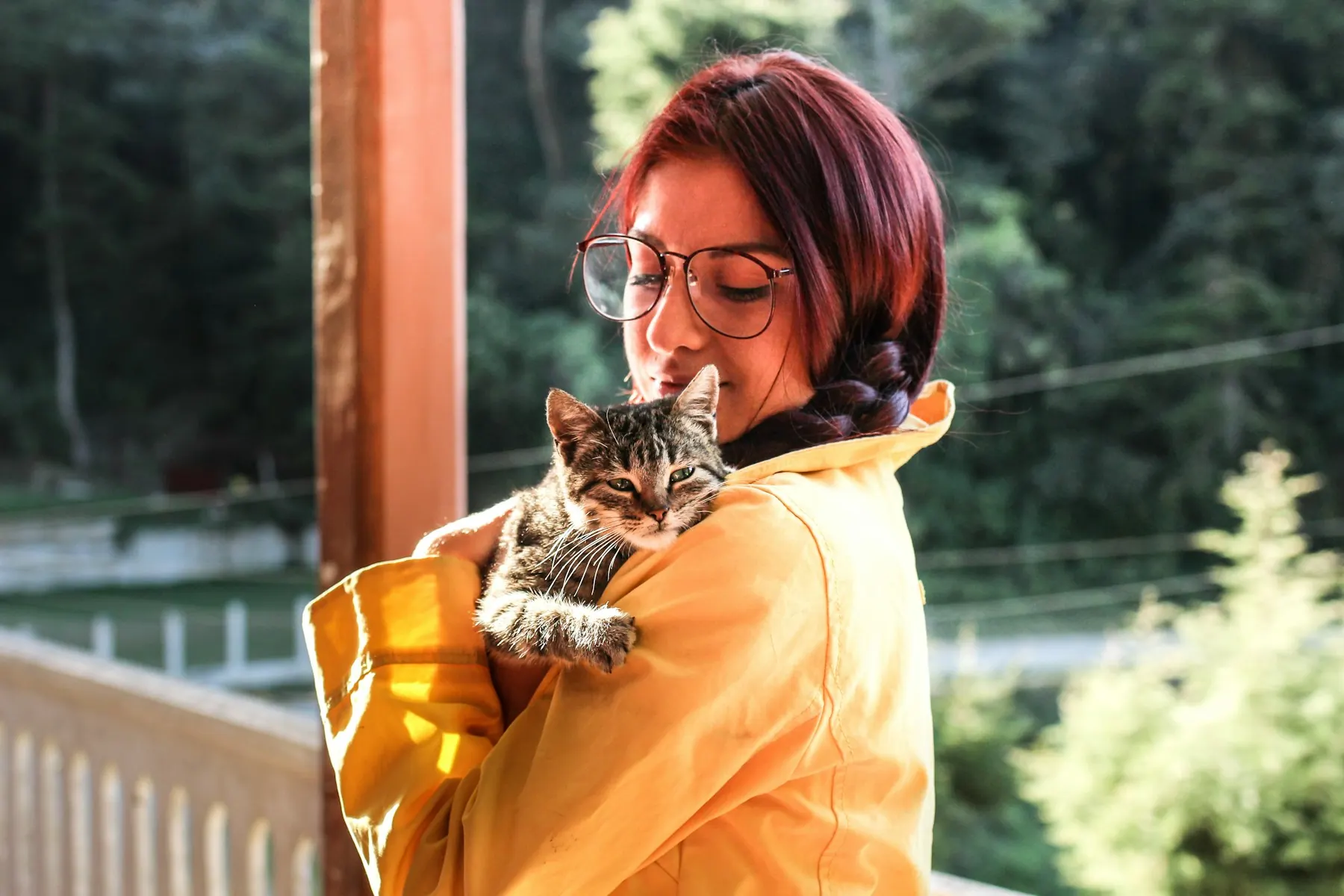 Eine Frau trägt ihre Katze auf der Schulter